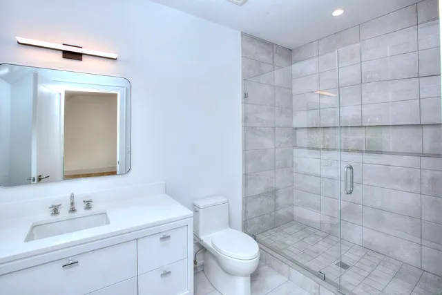 a bathroom with a sink a toilet and a mirror