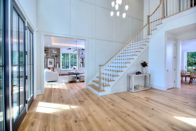 a view of a livingroom with wooden floor and stairs