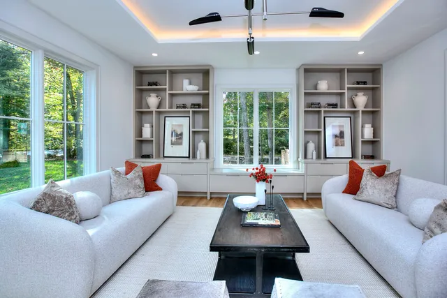 a living room with furniture large window and ceiling fan