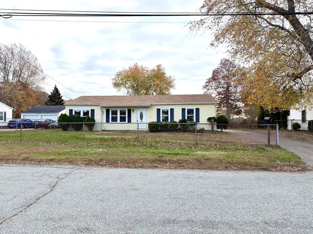 a front view of a house with a yard and trees