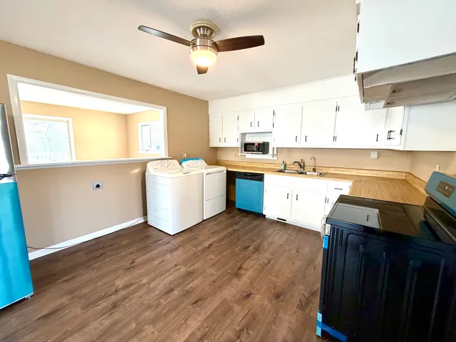 a kitchen with wooden floors and white cabinets