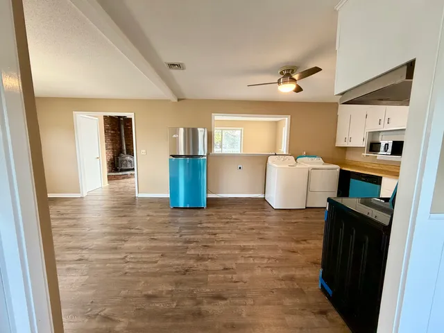 a view of a kitchen with a sink and dishwasher a refrigerator with wooden floor
