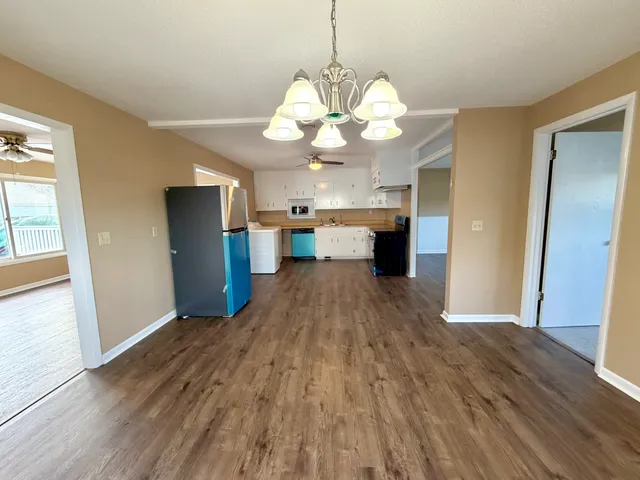 a view of a kitchen with a dishwasher wooden floor and a large window