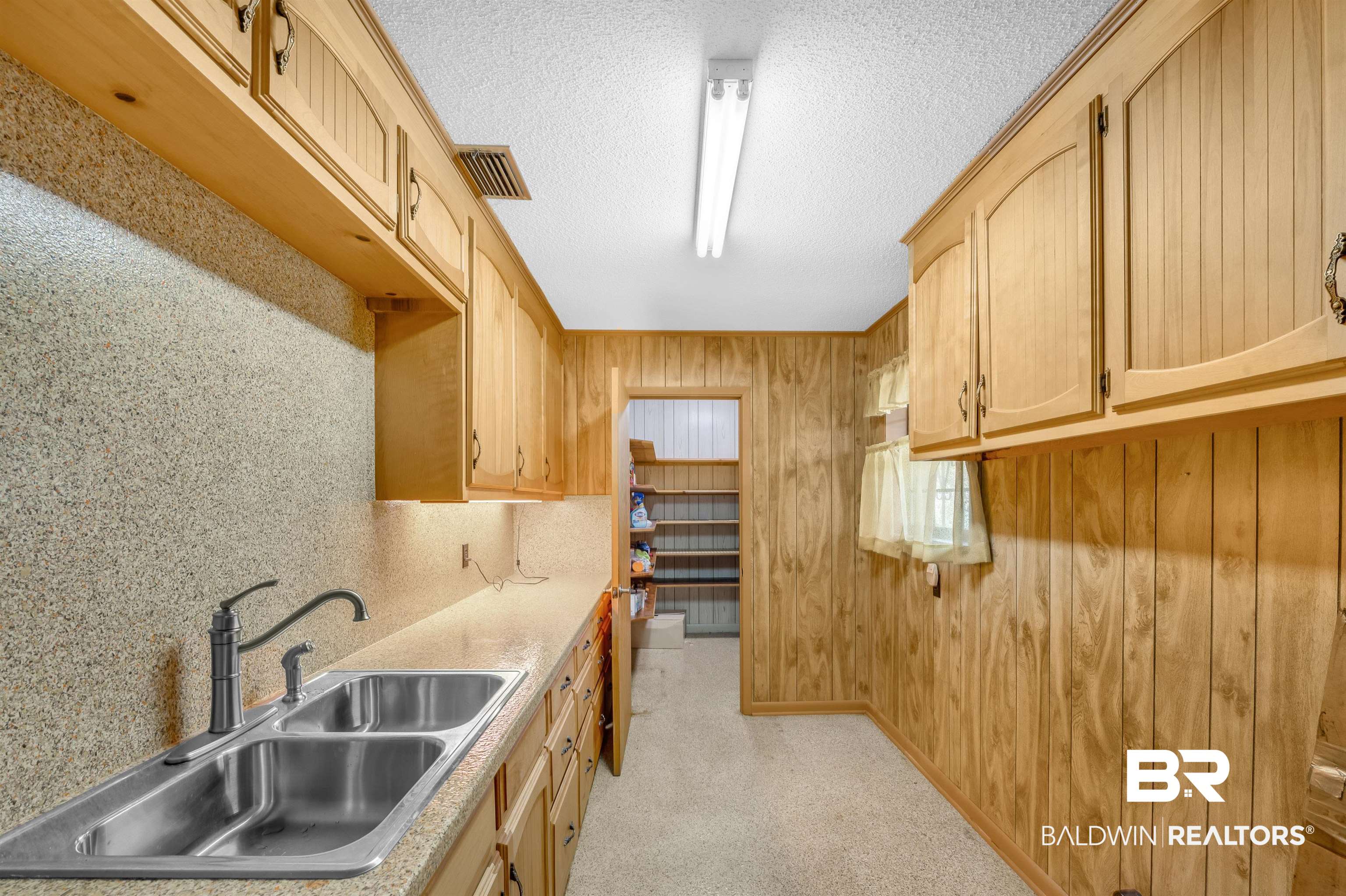 610 East Walker Avenue Foley, AL 36535 - Photo 21 of 38 Kitchen with wood walls, a textured ceiling, light countertops, and light brown cabinetry