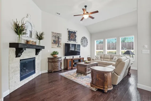 a living room with furniture a fireplace and a potted plant
