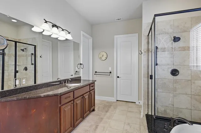 a bathroom with a shower sink and mirror