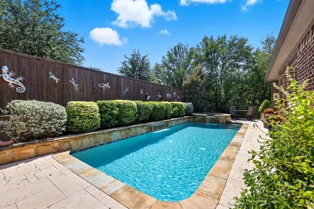 a view of a swimming pool with a patio and fire pit