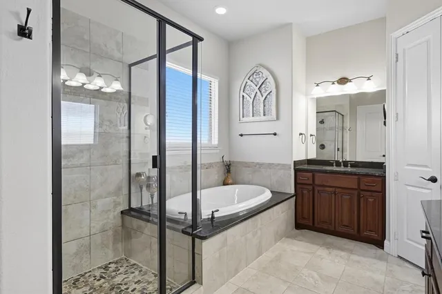 a bathroom with a tub a sink and mirror