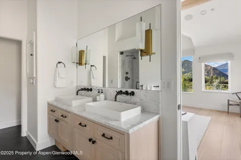 a bathroom with double vanity sink and mirror