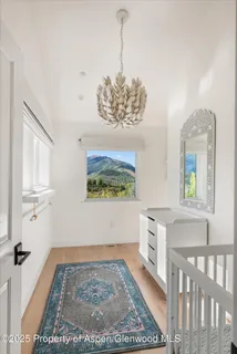 a view of a hallway with a white cabinets and wooden floor