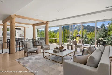 a living room with furniture and floor to ceiling windows