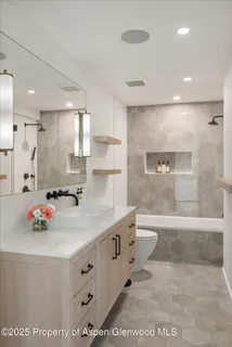 a bathroom with a sink mirror toilet and bathtub