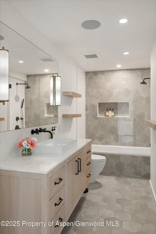 a bathroom with a sink mirror toilet and bathtub