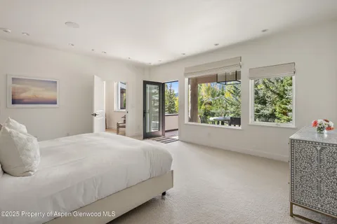 a bedroom with a bed and a large window