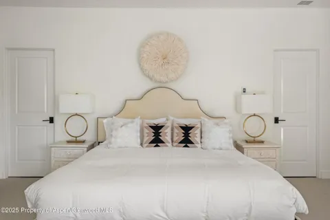 a bedroom with bed and a chandelier