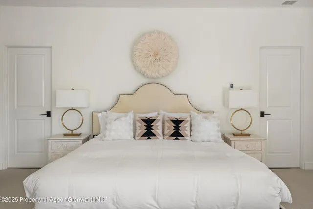 a bedroom with bed and a chandelier