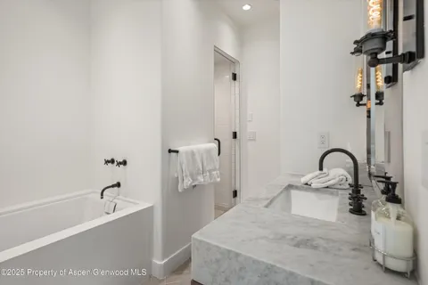 a bathroom with a tub sink and mirror