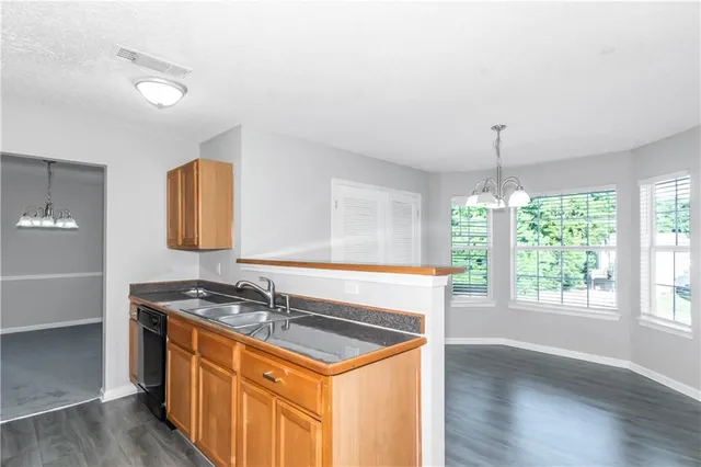 a kitchen with granite countertop a sink and a stove