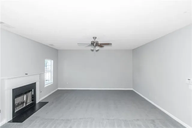 an empty room with windows and fireplace