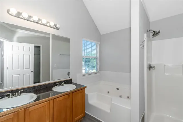 a bathroom with a granite countertop sink mirror and a bathtub