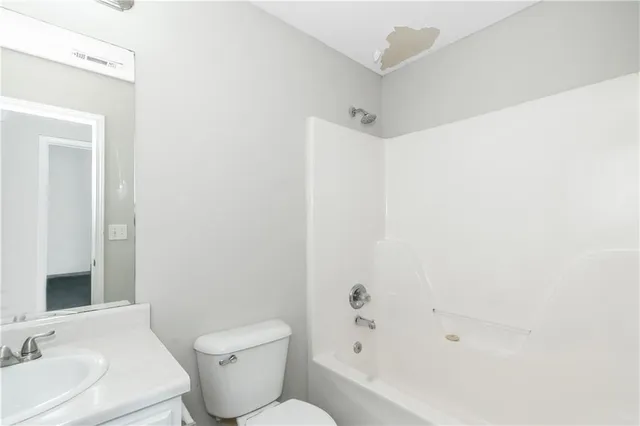 a white toilet sitting next to a bathroom sink
