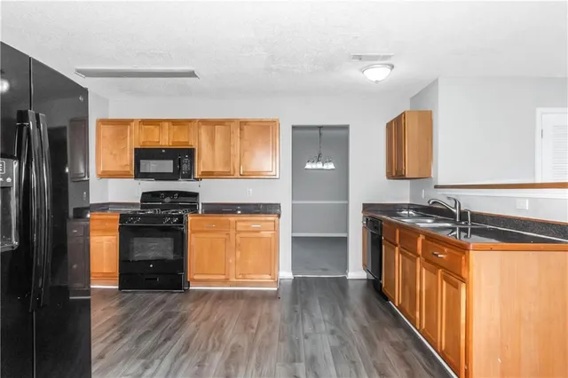 a kitchen with stainless steel appliances granite countertop a stove a sink and a refrigerator