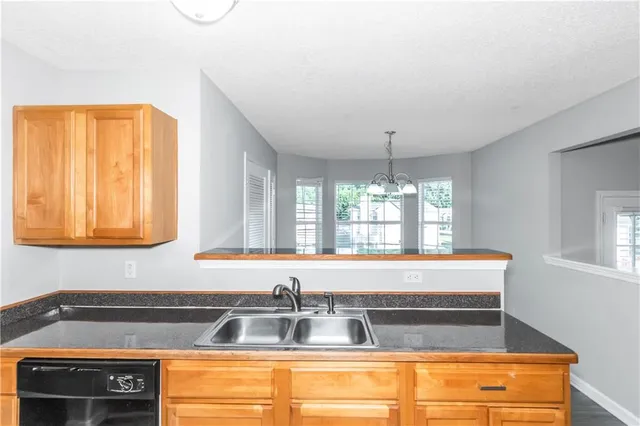 a view of a kitchen with kitchen island a sink appliances and a counter top