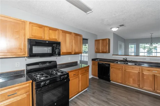 a kitchen with stainless steel appliances a stove sink and microwave