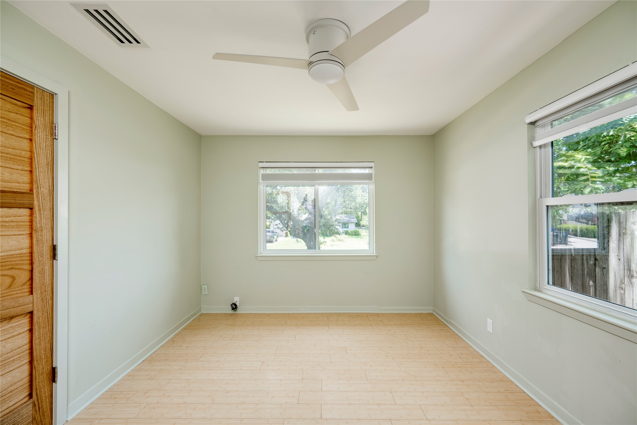 1707 Overhill Drive Austin, TX 78721 - Photo 16 of 36 A quiet bedroom featuring light wood flooring and a modern ceiling fan for comfort.