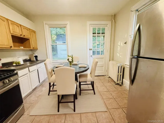 a dining room with stainless steel appliances a refrigerator stove and a window