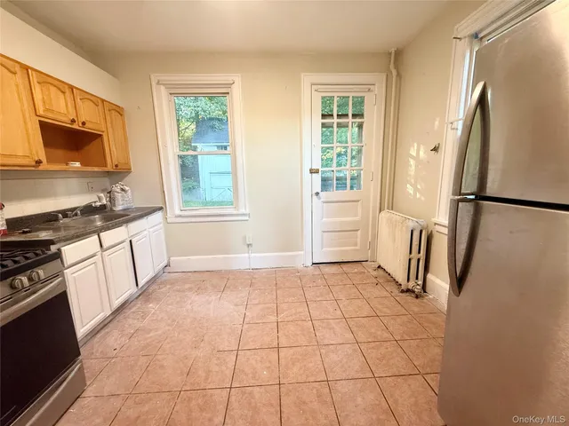 a kitchen with a refrigerator a stove a sink and a window