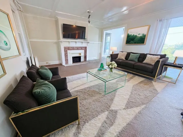 a living room with furniture a flat screen tv and a fireplace