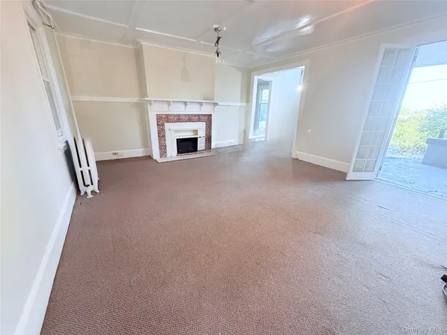 an empty room with fireplace and a window