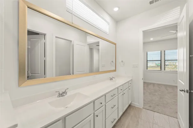 a bathroom with double vanity sinks and a mirror