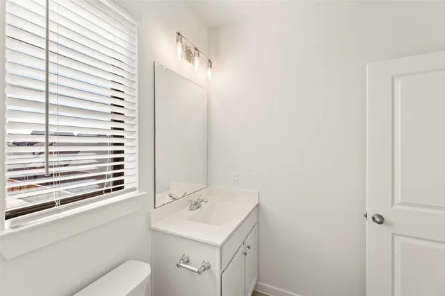 a bathroom with a sink a toilet and vanity