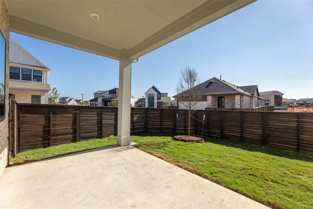 a view of a brick house with a small yard and wooden fence
