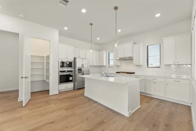 a large kitchen with cabinets and stainless steel appliances