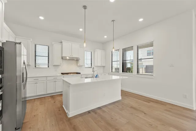 a kitchen with kitchen island a sink stainless steel appliances and cabinets