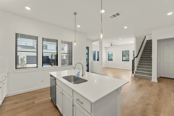 a kitchen with wooden floor window and staircase