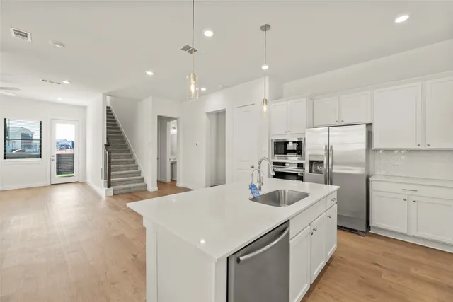 a kitchen with refrigerator cabinets and wooden floor