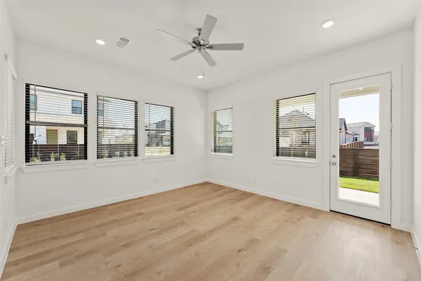 a view of an empty room with a window and wooden floor