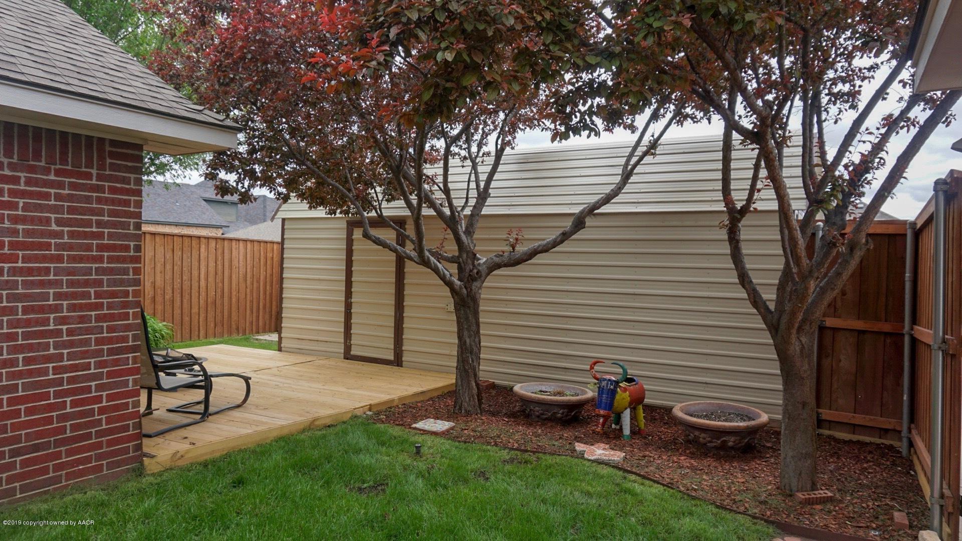 6605 Rally Road Amarillo, TX 79119 - Photo 18 of 21 a view of a backyard with chairs potted plants and large tree