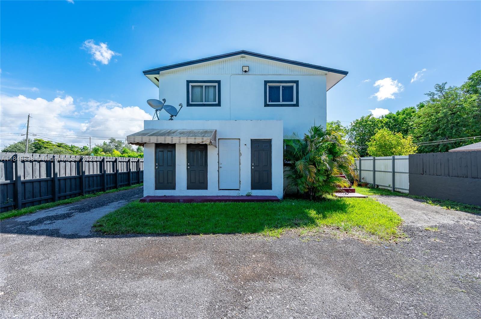 520 Southwest Krome Terrace, Unit 1 Homestead, FL 33030 - Photo 2 of 27 a front view of a house with garden