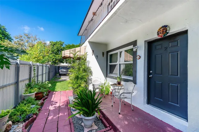 a room with a bed a couch and a potted plant