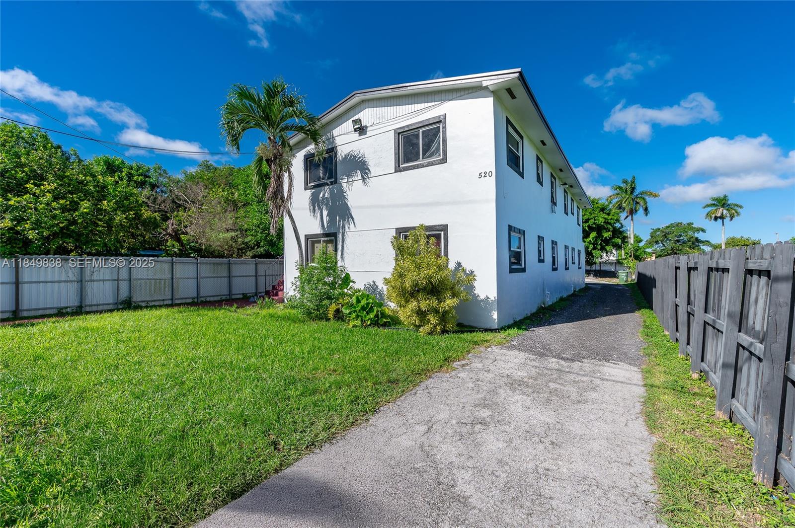 520 Southwest Krome Terrace, Unit 1 Homestead, FL 33030 - Photo 3 of 27 a white house with a small yard and wooden fence