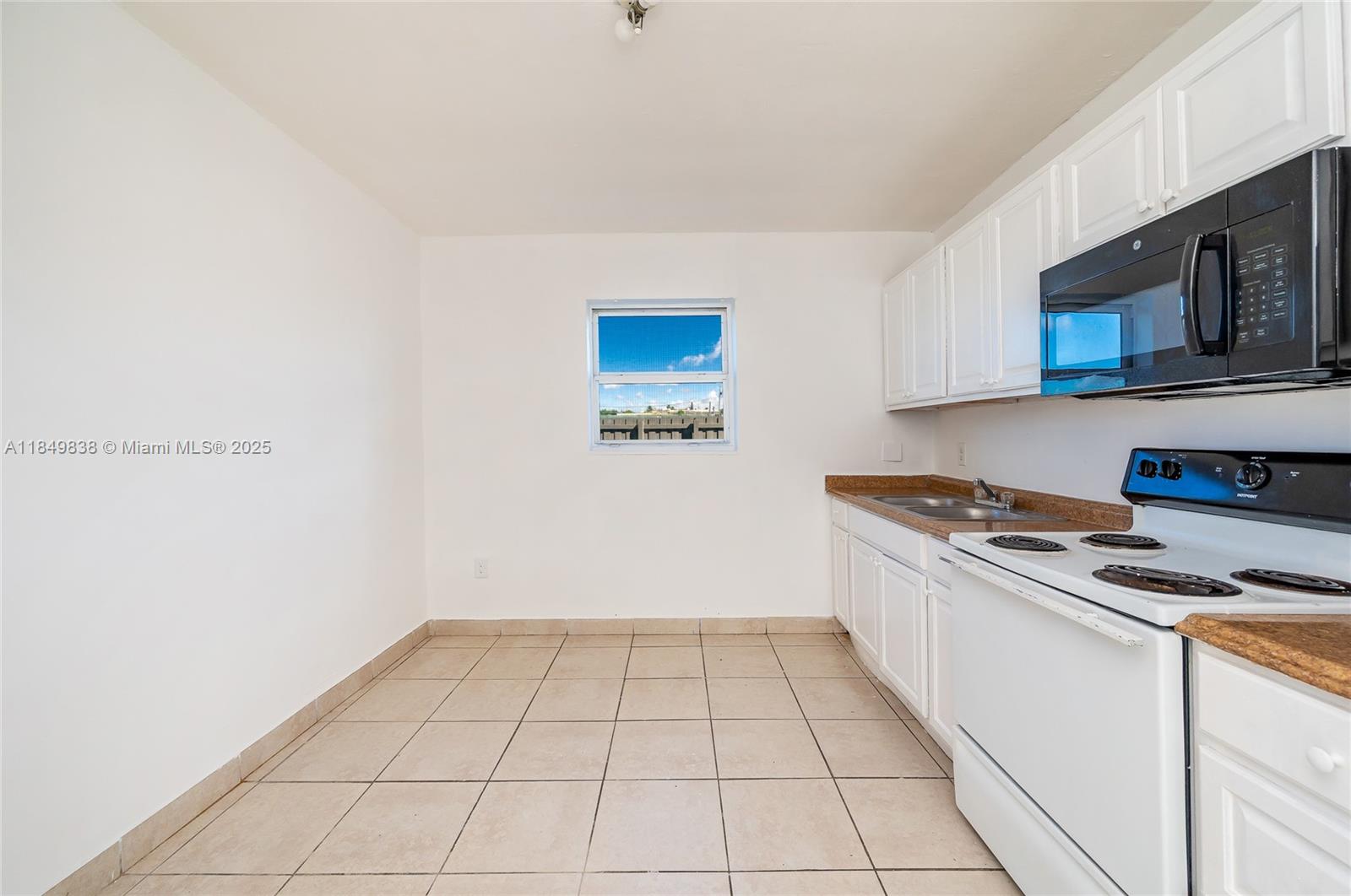 520 Southwest Krome Terrace, Unit 1 Homestead, FL 33030 - Photo 4 of 27 a kitchen with a stove cabinets and microwave