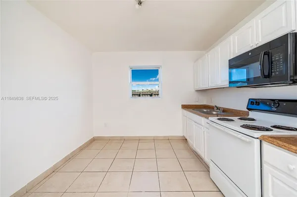 a kitchen with a stove cabinets and microwave