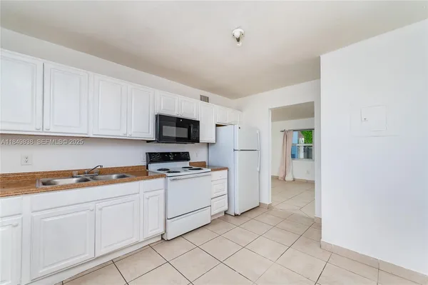 a kitchen with white cabinets and white appliances