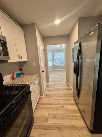 a kitchen with stainless steel appliances a refrigerator and a stove