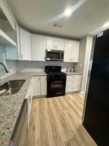 a kitchen with wooden cabinets and a stove top oven